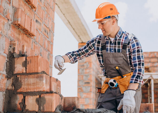 Young craftsman building a house