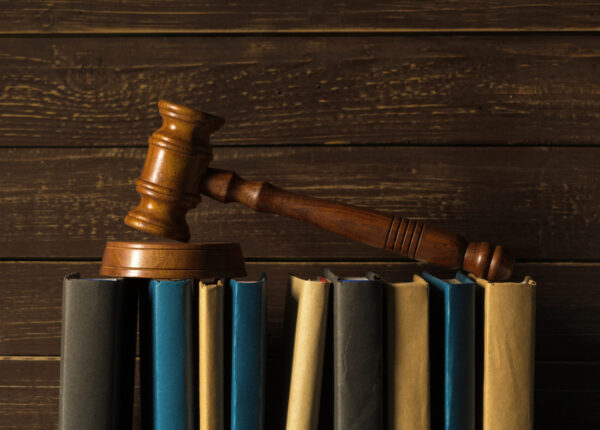 Gavel With Books On Old Wooden Desk